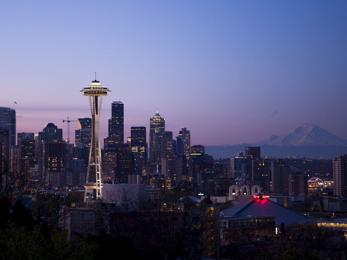 This image features the skyline of Seattle, with the Space Needle prominently in the foreground and Mount Rainier visible in the background.